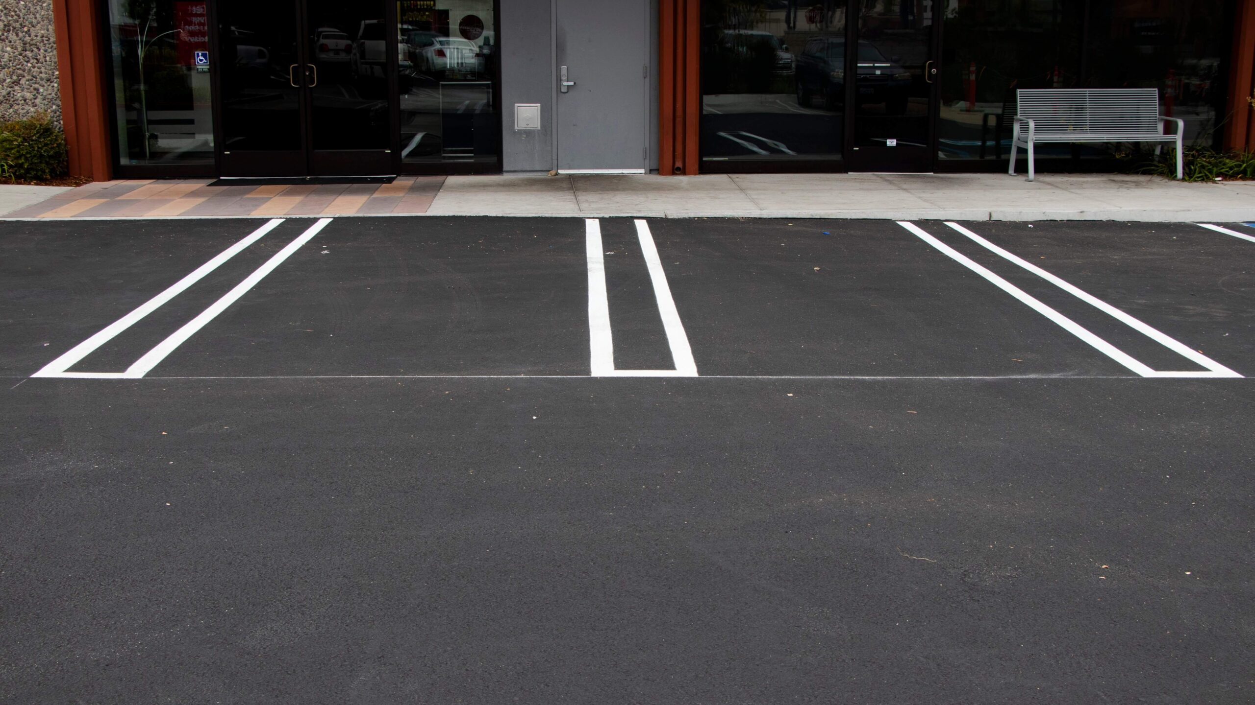 GPM's paving services laid fresh asphalt and striped parking spaces in the lot of retail stores.